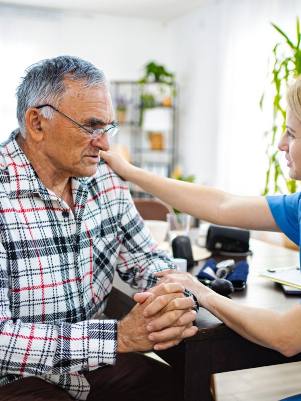 Caring nurse helps senior man in a bright clinic
