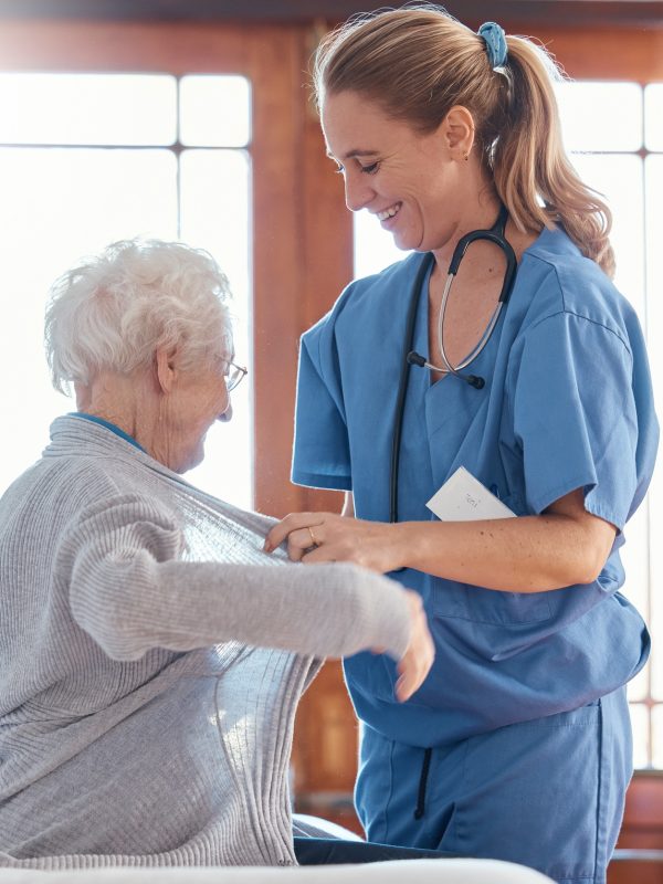 Nurse, healthcare and senior woman in nursing home with physician helping her dress up. Disability,