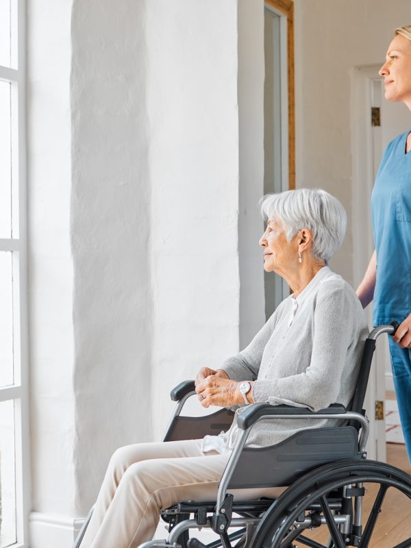 Shot of a nurse caring for a senior woman in a wheelchair in a retirement home